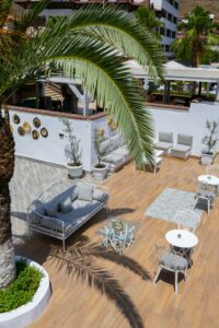 Charming outdoor patio area in Marmaris with seating and palm trees, perfect for relaxation.