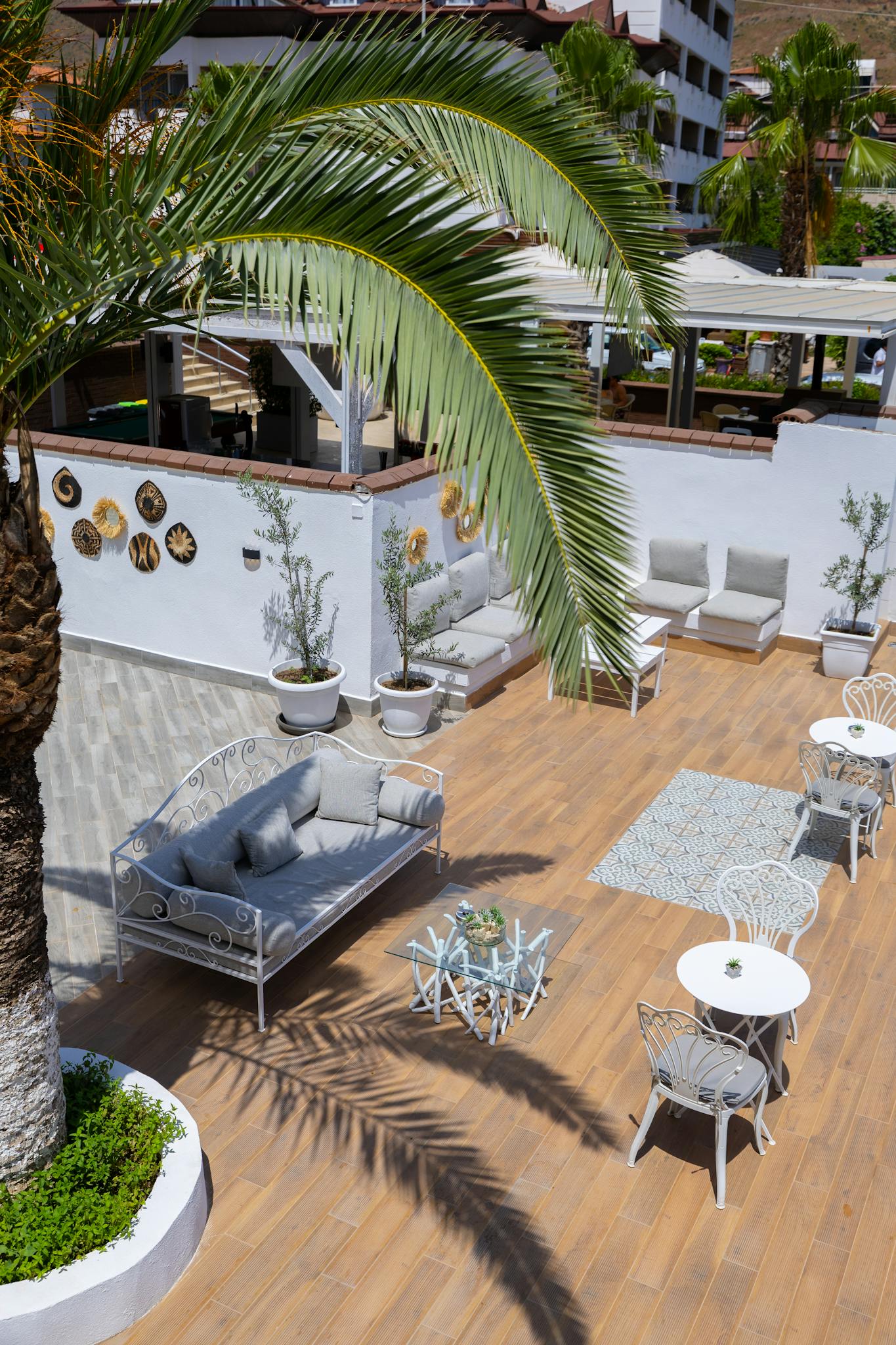 Charming outdoor patio area in Marmaris with seating and palm trees, perfect for relaxation.