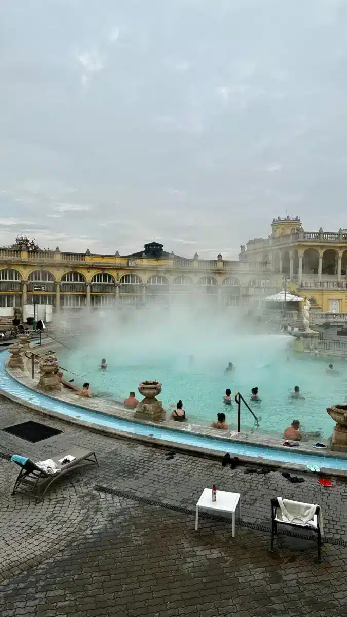 Dampfender Außenpool des Széchenyi Thermalbads Budapest an einem bewölkten Wintertag mit Blick auf die neobarocke Fassade
