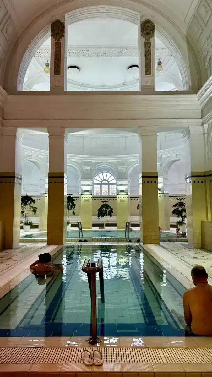 Innenbecken im Széchenyi Thermalbad Budapest mit hohen Gewölbedecken und neobarocken Säulen