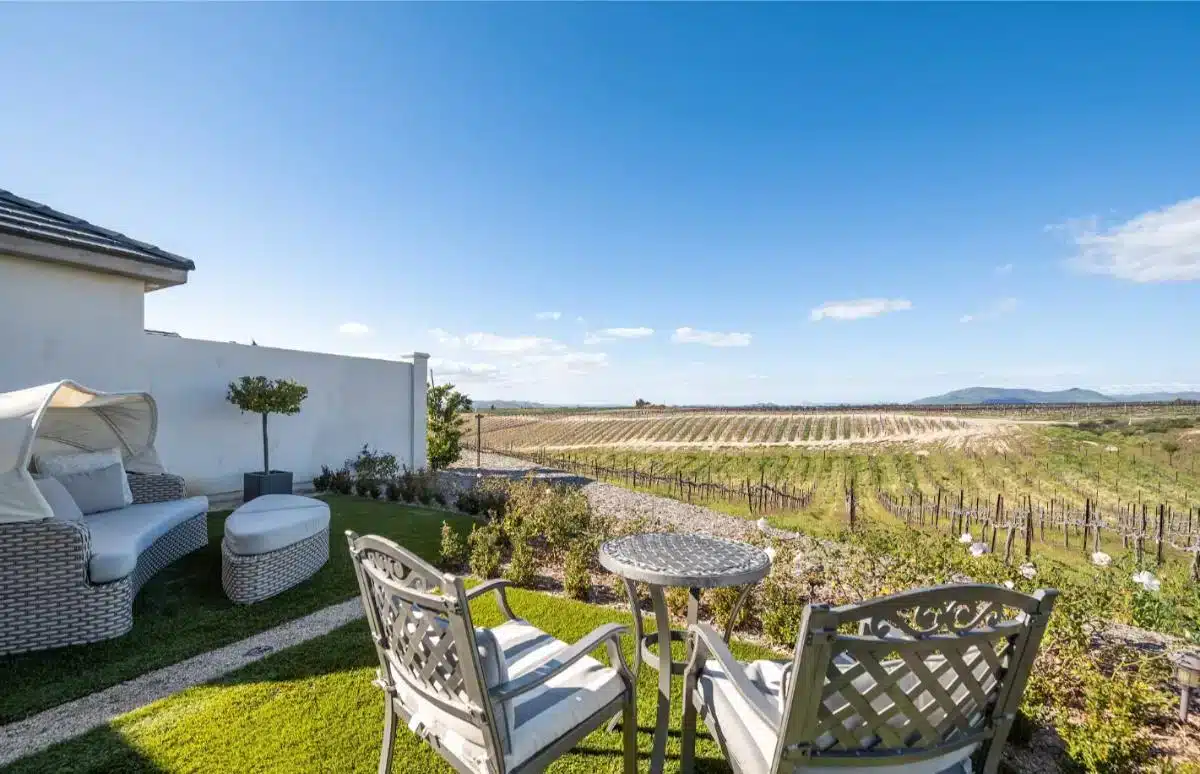 Private Außenterrasse einer Gästesuite von Domaine Chardonnay mit Korbmöbeln und Blick über die Weinbergreihen auf die Berge des Temecula Valley