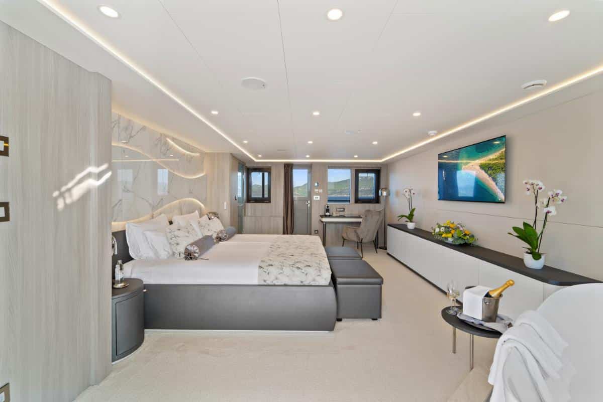 Moderne Luxuskabine mit Bett und großen Panoramafenstern an Bord der Yacht Freedom