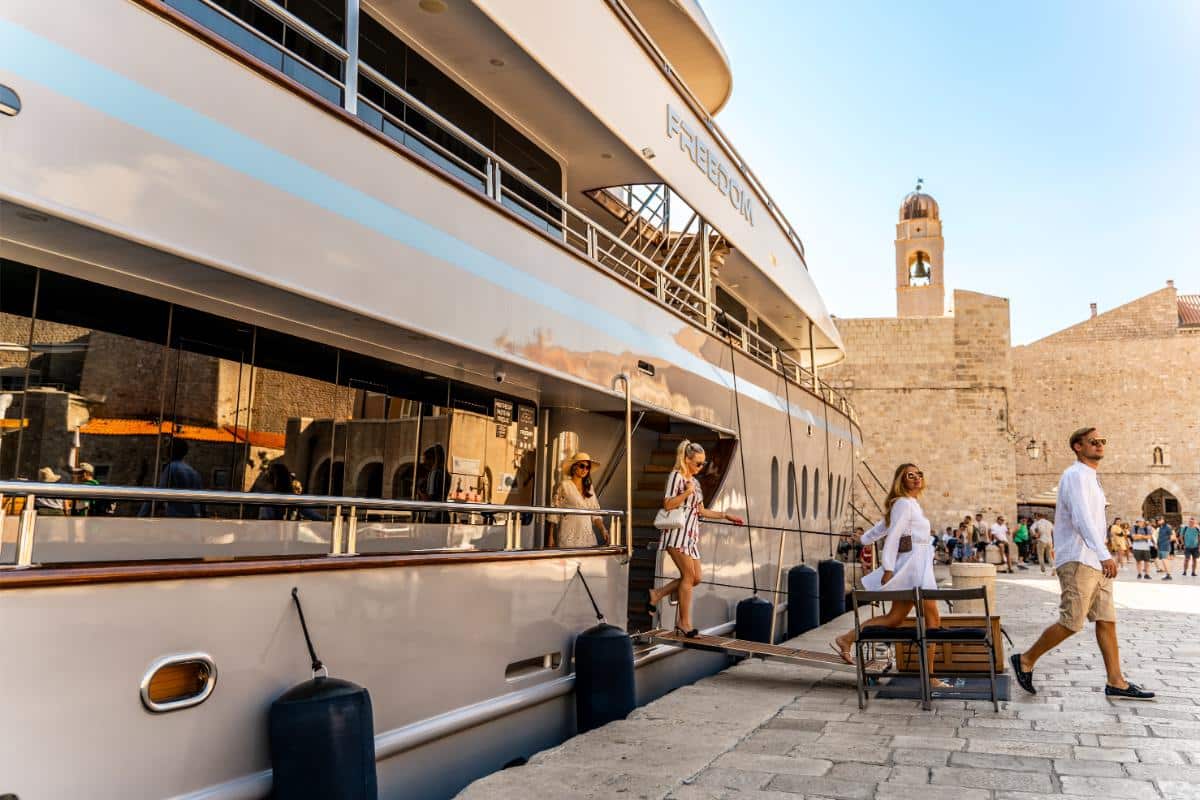 Außendeck der Yacht Freedom mit Gästen die ein Dinner im Freien genießen