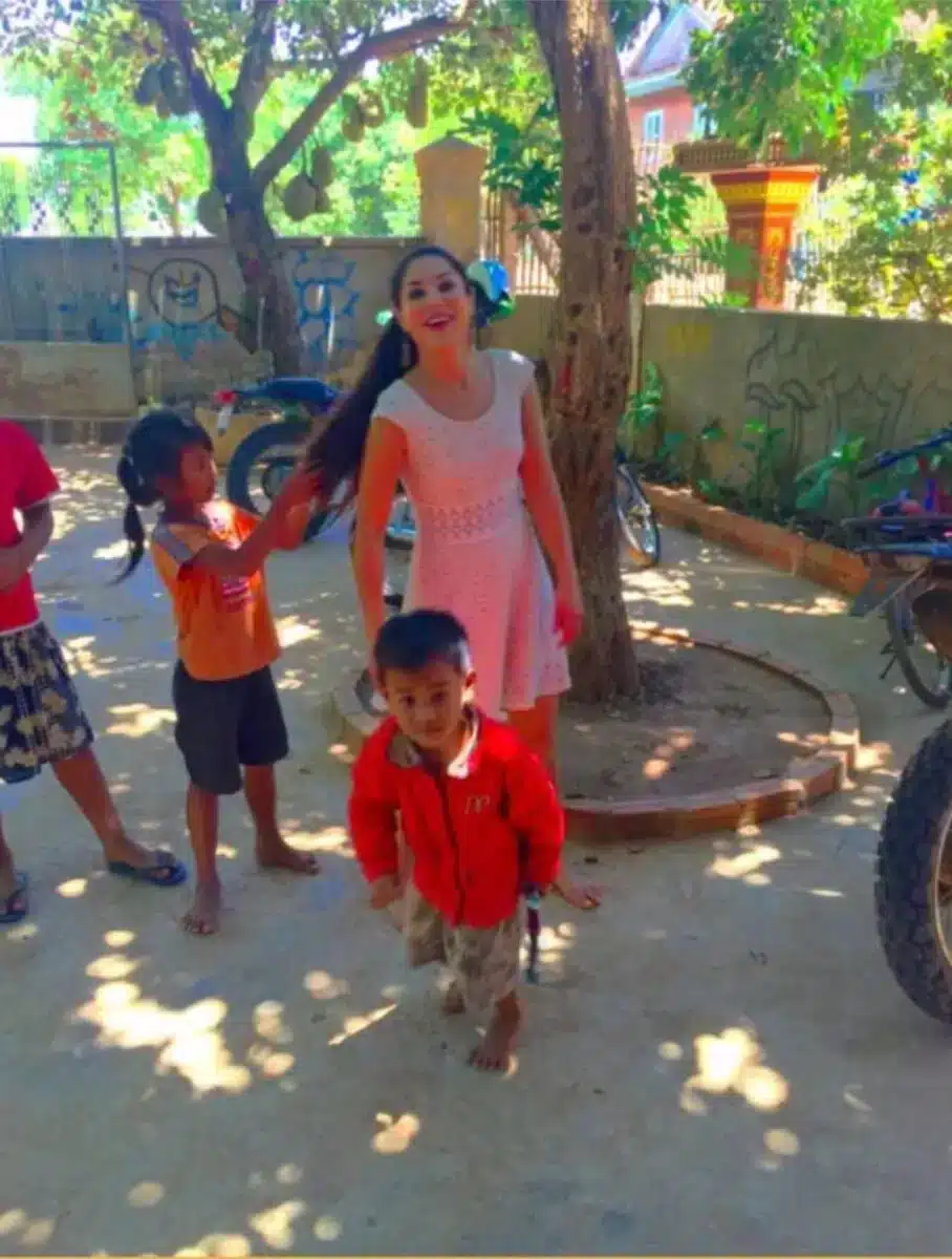 Sayé Yabandeh im Austausch mit kleinen Kindern im Freien während eines humanitären Besuchs in Indien