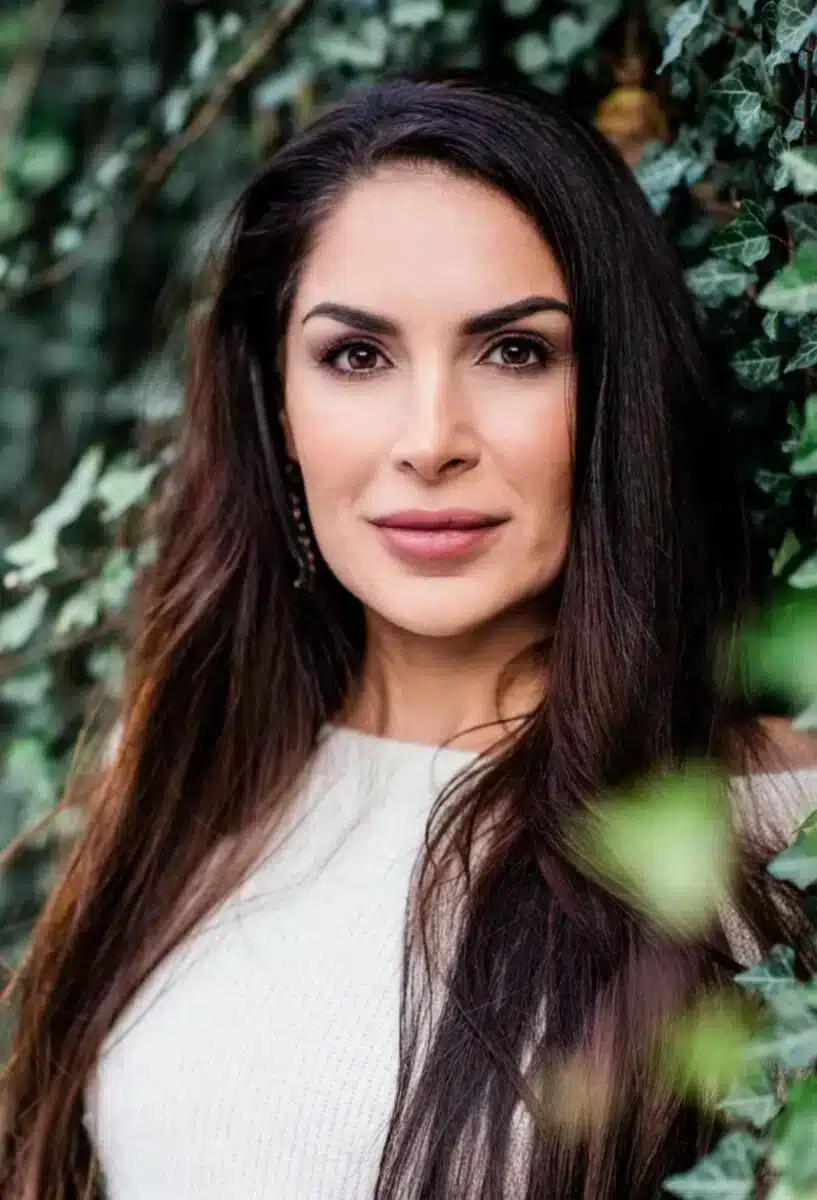 Portrait von Sayé Yabandeh, Gründerin von Sacred Ascension Journeys, mit natürlichem grünem Laub im Hintergrund