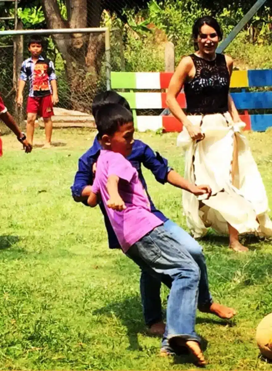 Kinder spielen draußen auf einer Wiese während eines Gemeinschaftsprojekts von Sacred Ascension Journeys in Indien