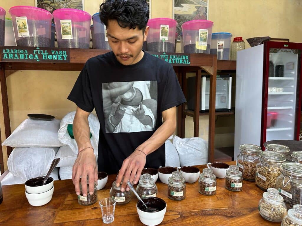 Barista bereitet individuelle Kaffeeverkostungsproben im Verkostungsraum der Munduk Moding Plantation Bali vor mit Arabica-Honey-Sortenpaketen