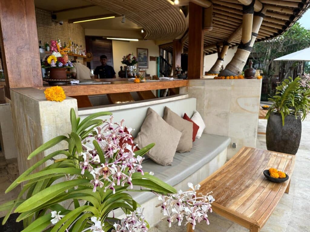 Poolbar-Tresen der Munduk Moding Plantation Bali dekoriert mit frischen lila Orchideen und gepolsterten Sitzen