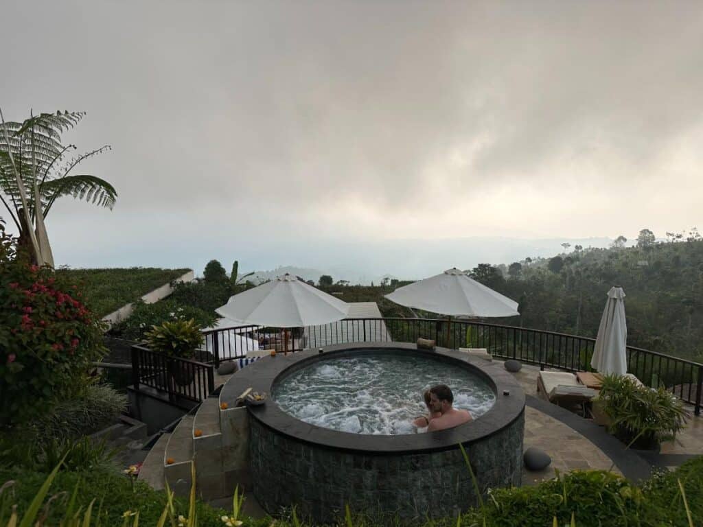 Romantisches Abendessen im Freien in der Munduk Moding Plantation Bali mit Whirlpool auf der Hügelkuppe, Blumenarrangements und sanfter Beleuchtung