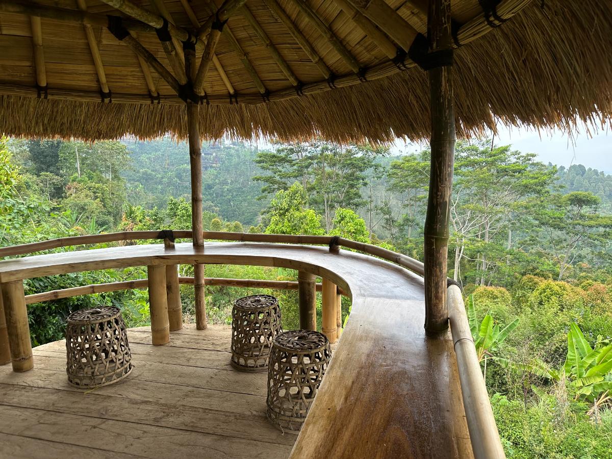 Privater Terrassentisch für zwei der Munduk Moding Plantation Bali mit Orchideen und Blick auf den nebeligen Plantagenhang