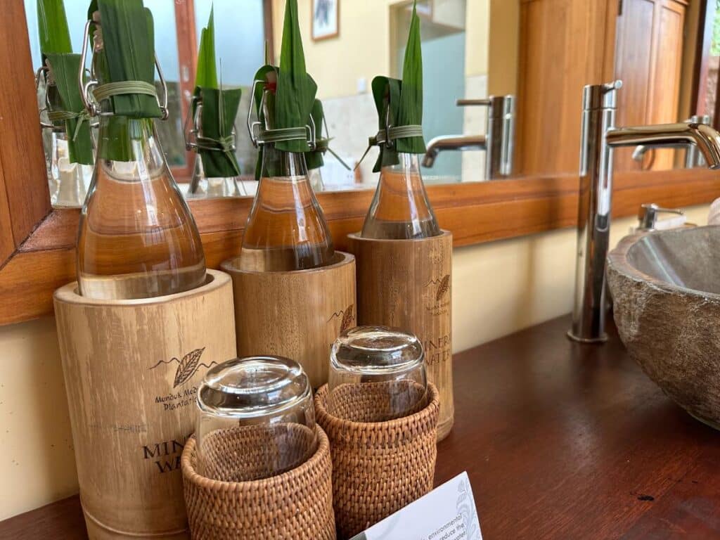 Nachhaltige Pflegeflaschen in Bambushüllen aufgereiht im Badezimmer der Munduk Moding Plantation Bali Villa