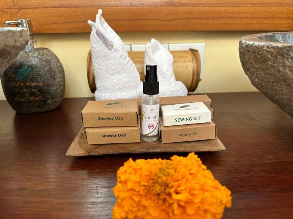 Badezimmer-Ablage mit Munduk Moding Plantation Pflegeprodukten, balinesischer Ringelblumen-Opfergabe und handgefertigten Bambusbehältern