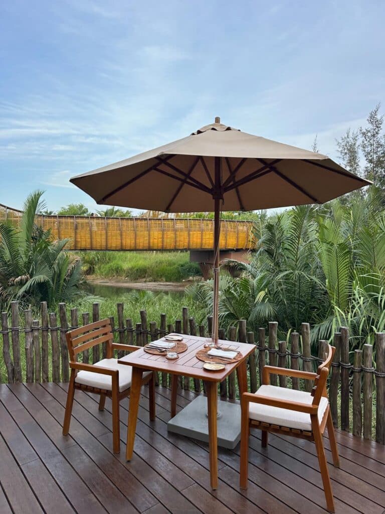 Riverside breakfast table set beside the Thu Bon River, The Merchant, Namia River Retreat, Hoi An, Vietnam