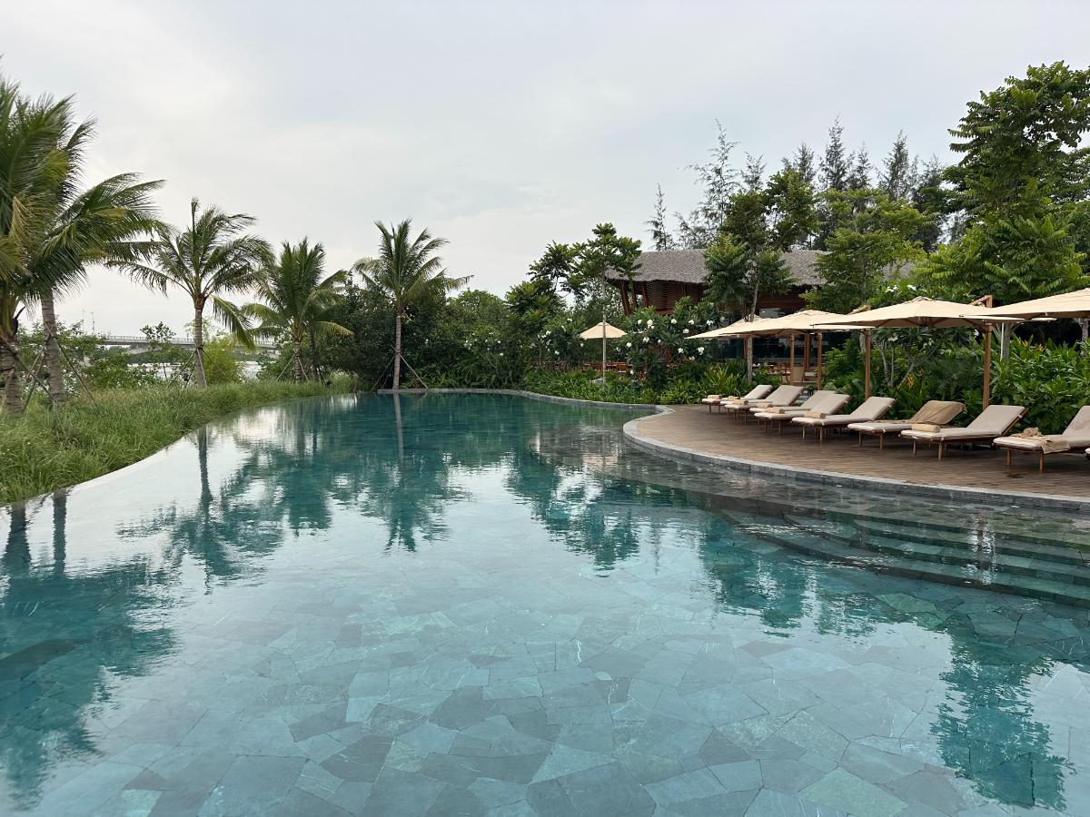 Main infinity pool and loungers facing the Thu Bon River, Namia River Retreat, Hoi An, Vietnam