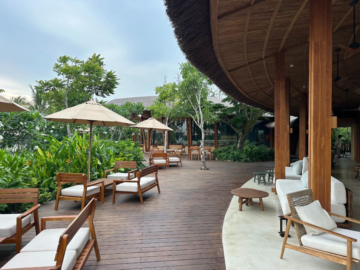 Open-air timber pool deck with loungers under the bamboo pavilion roof, Namia River Retreat, Hoi An, Vietnam