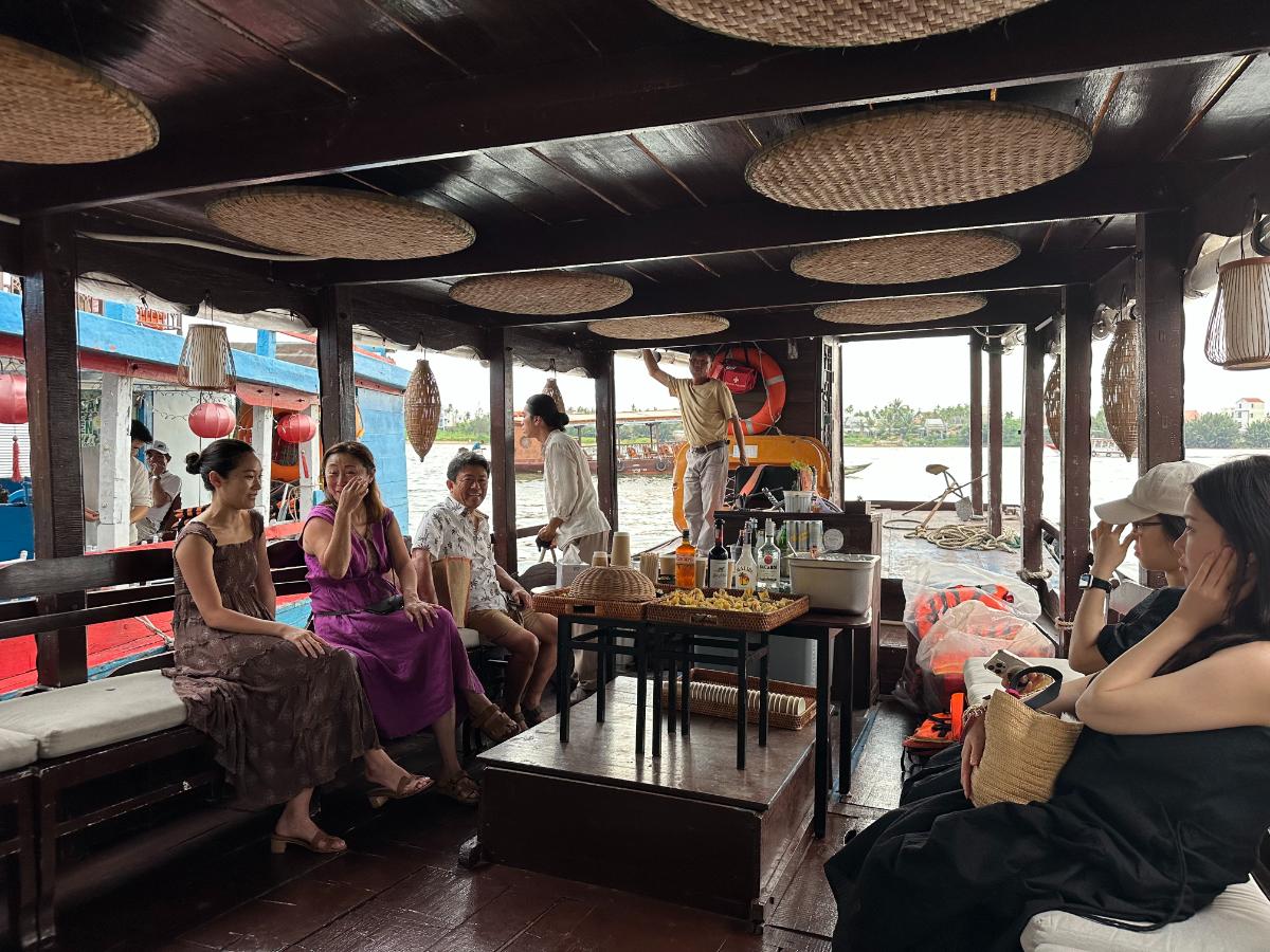 Guests gathered inside the Namia river cruise lounge with lanterns, Hoi An, Vietnam