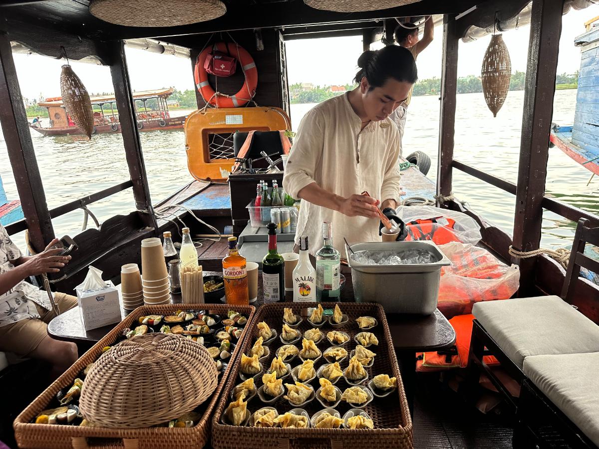 Bartender preparing snacks and drinks aboard the Namia river cruise, Hoi An, Vietnam