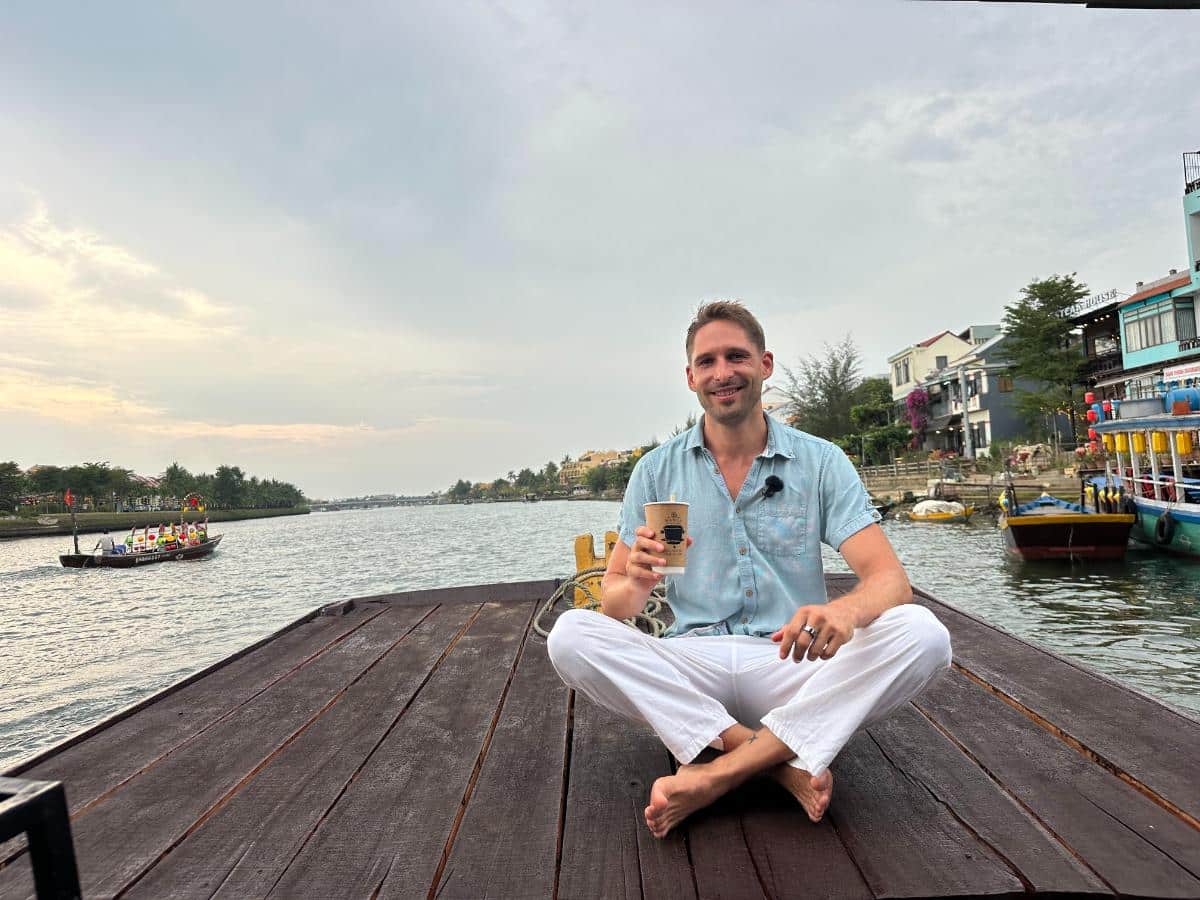 Guest with a drink on the bow of the Namia river cruise, Thu Bon River, Hoi An, Vietnam