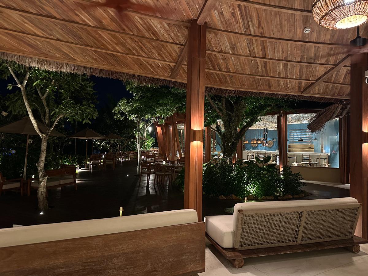 Open-sided bar and lounge under thatched roof at night, Namia River Retreat, Hoi An, Vietnam