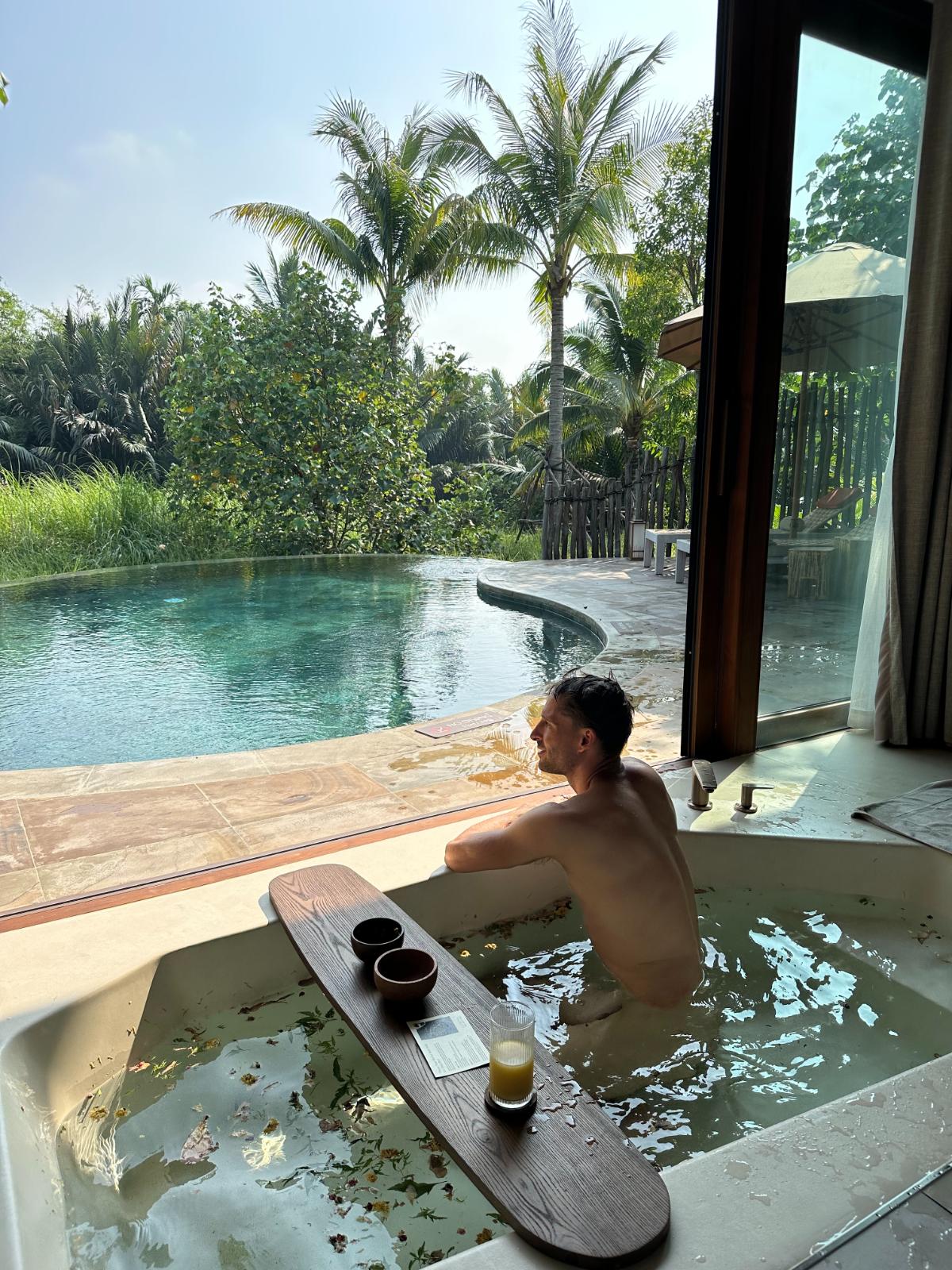 Guest soaking in private plunge pool with cocktails at a pool villa, Namia River Retreat, Hoi An, Vietnam