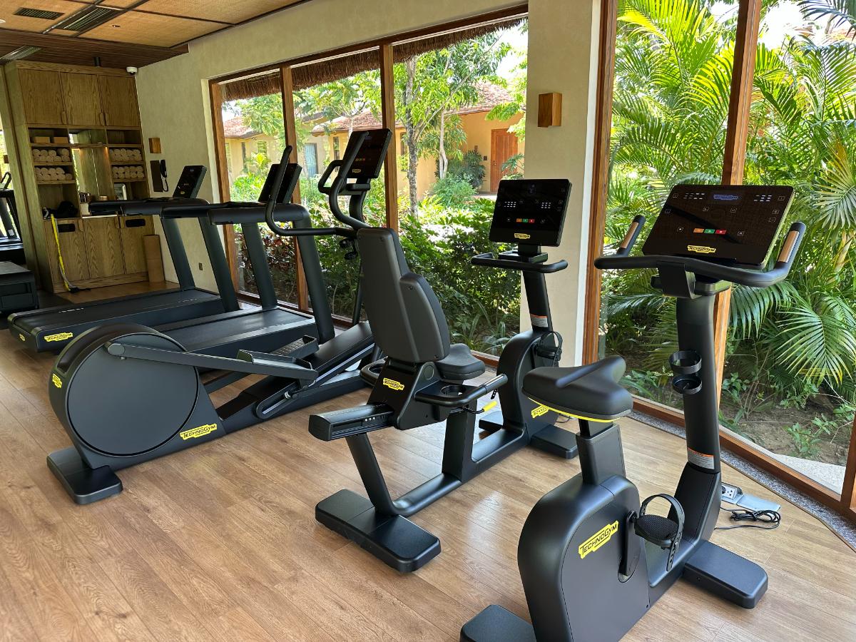 Treadmill and exercise bike along the gym window onto the garden, Namia River Retreat, Hoi An, Vietnam