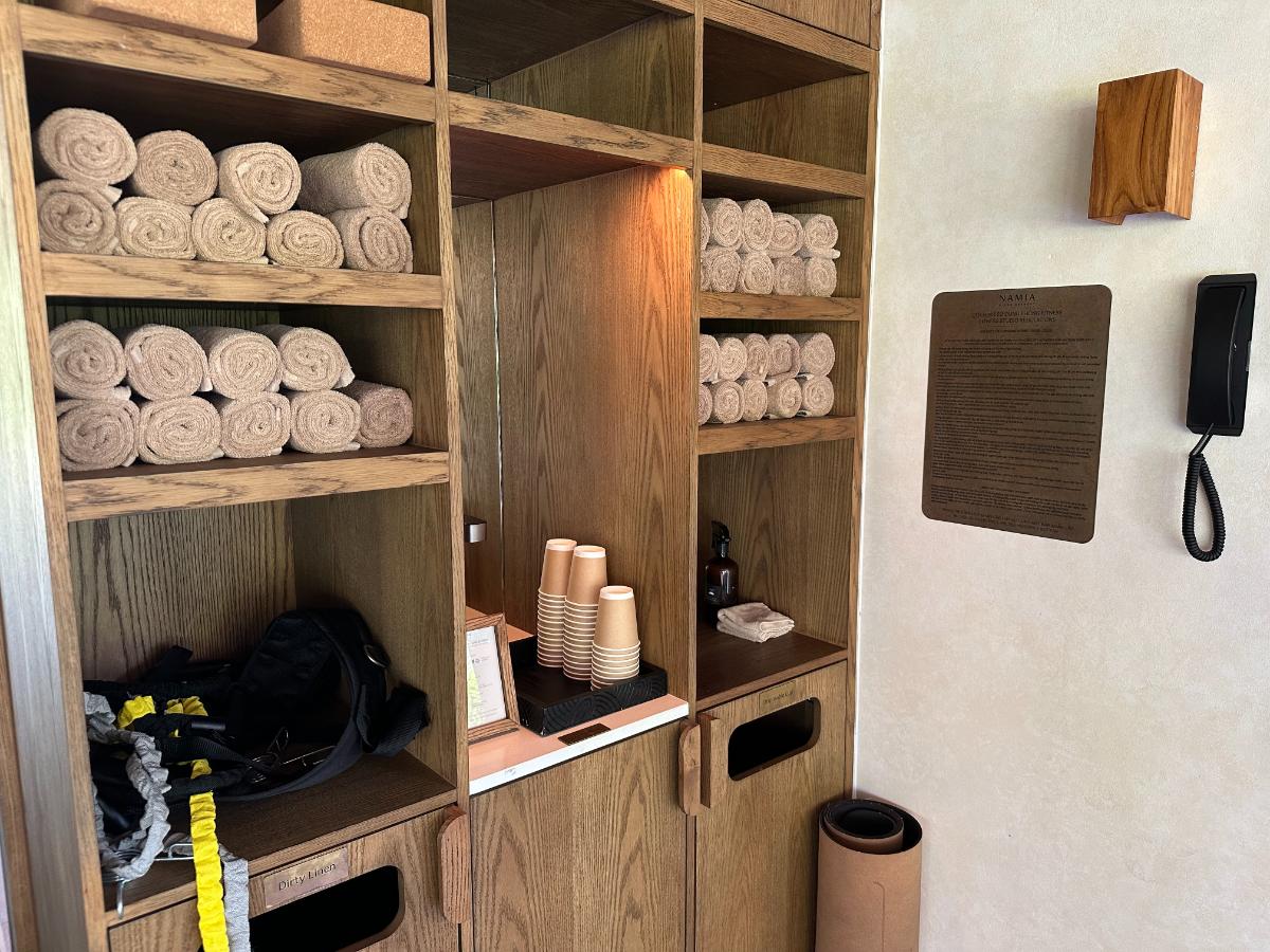 Rolled gym towels and amenities in the wooden fitness shelving, Namia River Retreat, Hoi An, Vietnam