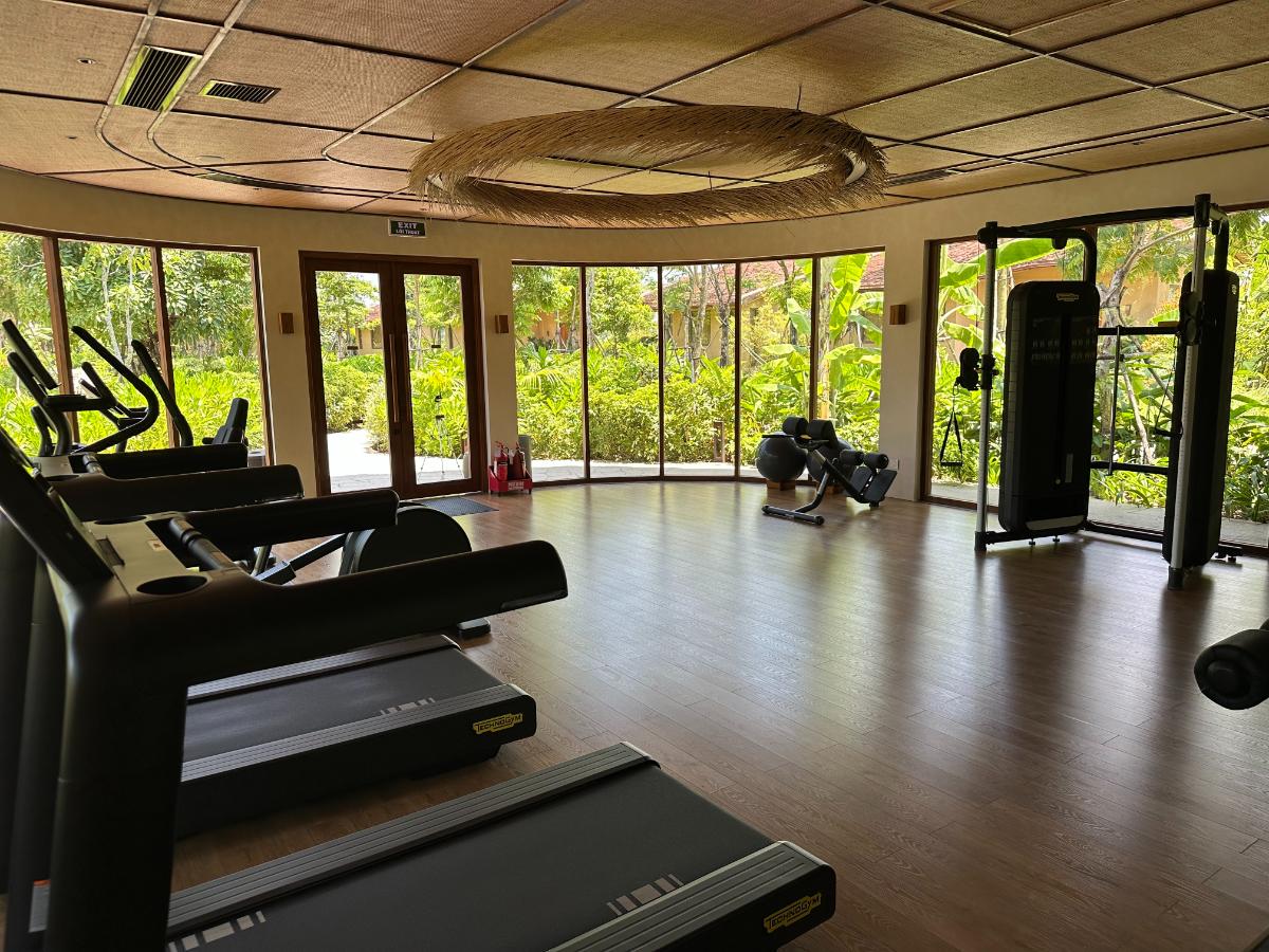 Gym interior with cardio line and curved bamboo ceiling facing the garden, Namia River Retreat, Hoi An, Vietnam