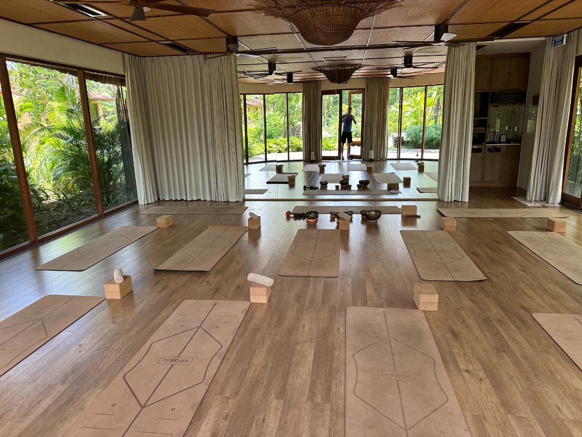 Yoga studio with mats arranged and floor-to-ceiling glass to the garden, Namia River Retreat, Hoi An, Vietnam