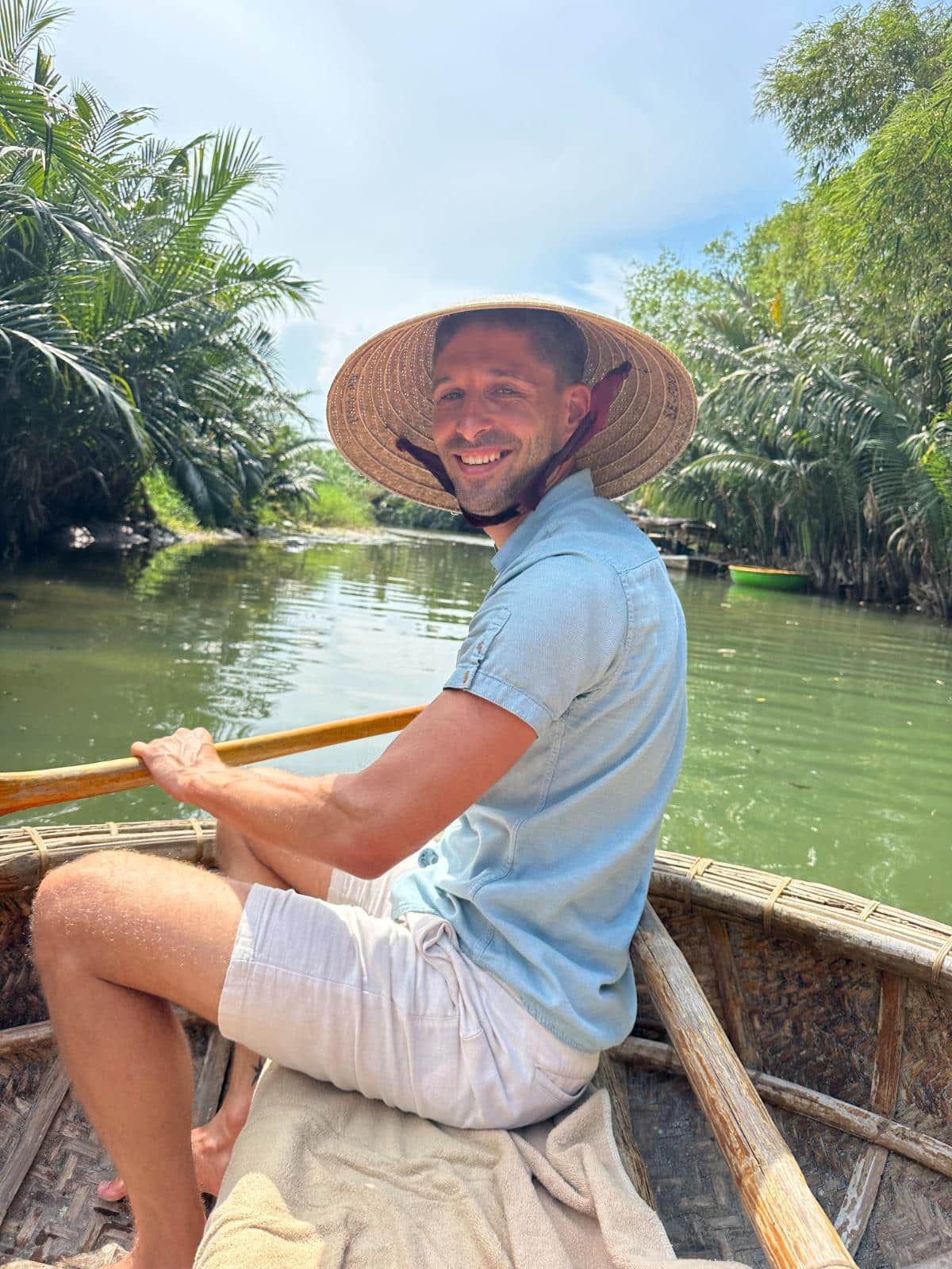 Paddling a bamboo basket boat on the river in a conical hat, Namia River Retreat experience, Hoi An, Vietnam