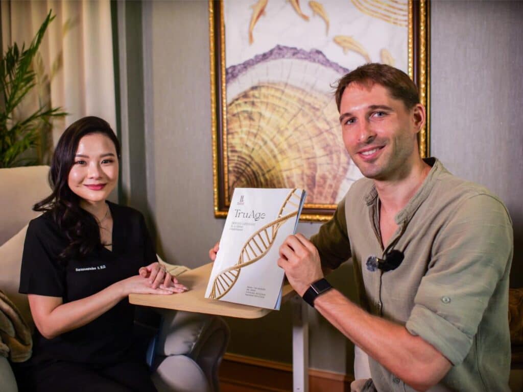 Tim Kroeger with his biological age test results and Dr. Petch at Healthi Life in Bangkok